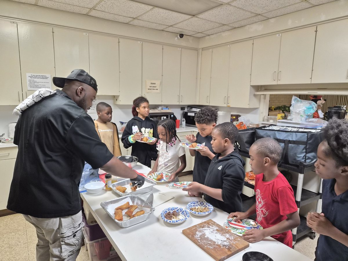 Chef Kareem Pearson serving fresh food to children during a free cooking class
